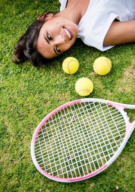 Portrait of a female tennis player lying on the lawn