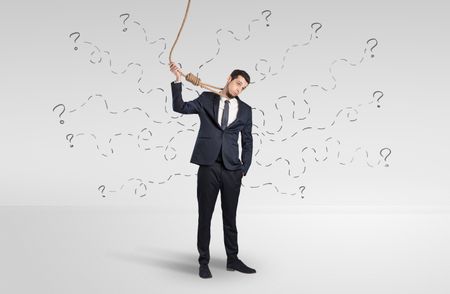 Hopeless young businessman trying to suicide with question signs concept