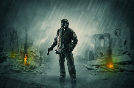 Destroyed place after a catastrophe with man in gas mask and weapon on his hand