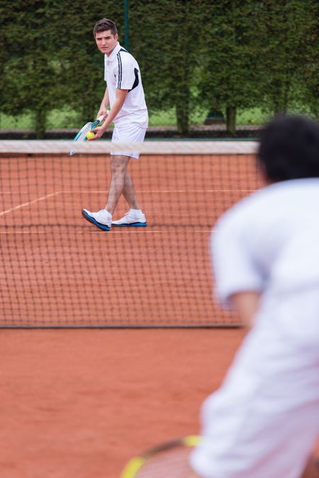 Men playing a tennis match at the court