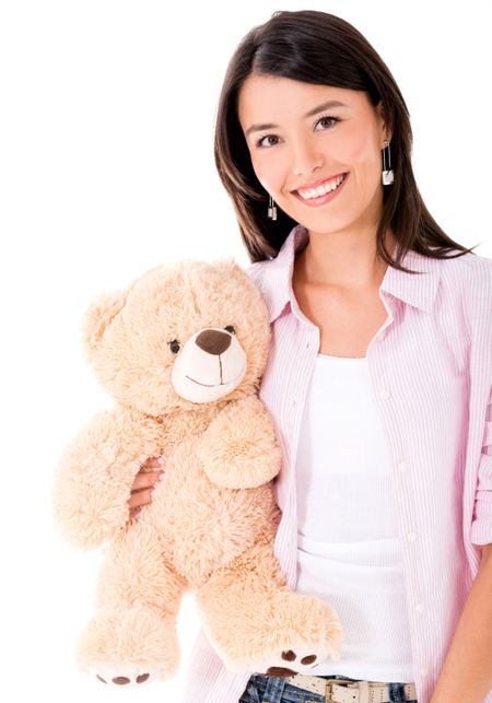 Casual woman holding a teddy bear and smiling - isolated over white