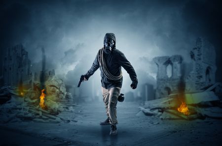 Destroyed place after a catastrophe with man in gas mask and weapon on his hand