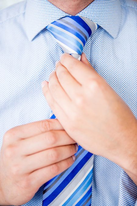 Close up of a business man fixing his tie