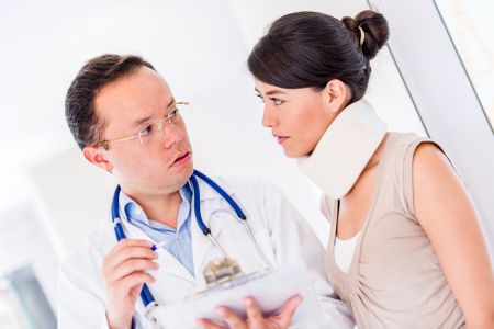 Injured woman at the doctor wearing an orthopedic collar