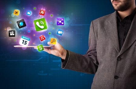 Young businessman holding a tablet with modern colorful apps and icons