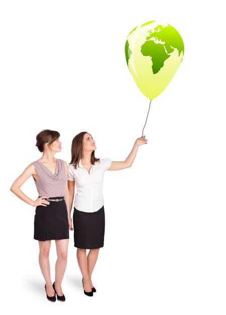 Happy young ladies holding a green globe balloon