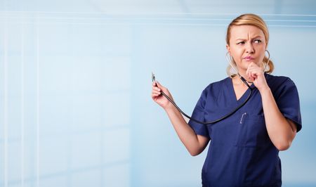 Pretty young nurse in hospital listening to empty copy space with sthetoscope