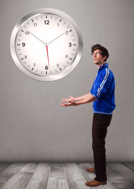 Attractive young boy holding a huge clock