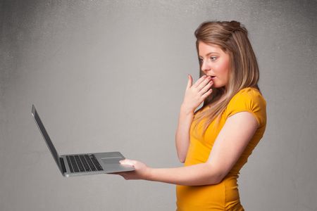 Pretty young woman holding modern laptot