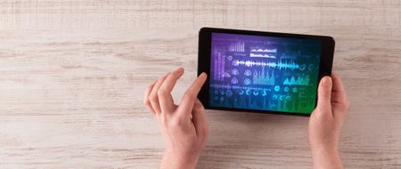 Hand touching tablet with waveforms and sound design concept