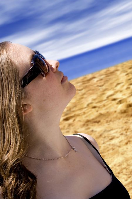 beautiful woman by the beach wearing sunglasses