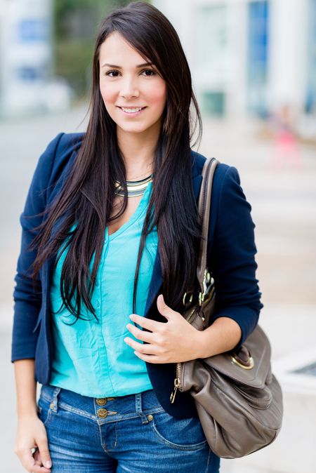 Beautiful casual woman on the street holding her purse