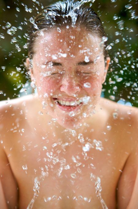 beautiful woman refreshing her face with a pure water splash