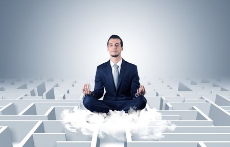 Businessman meditates on a cloud with maze concept