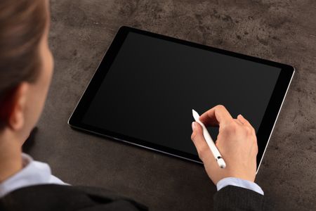 Business woman working on empty tablet with pencil