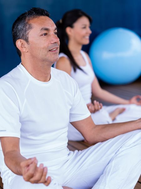 Couple practicing yoga and looking very relaxed