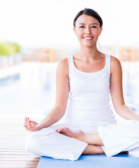Beautiful woman practicing yoga looking very happy