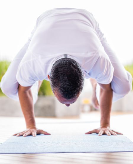 Yoga man meditating in a difficult position