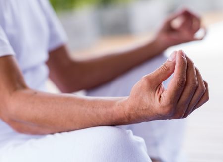 Yoga man meditating and making a zen symbol with his hand