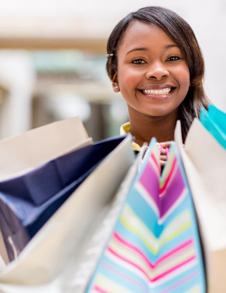 Happy female shopper holding shopping bags and smiling