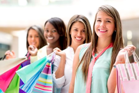 Happy girls shopping at the mall and holding bags