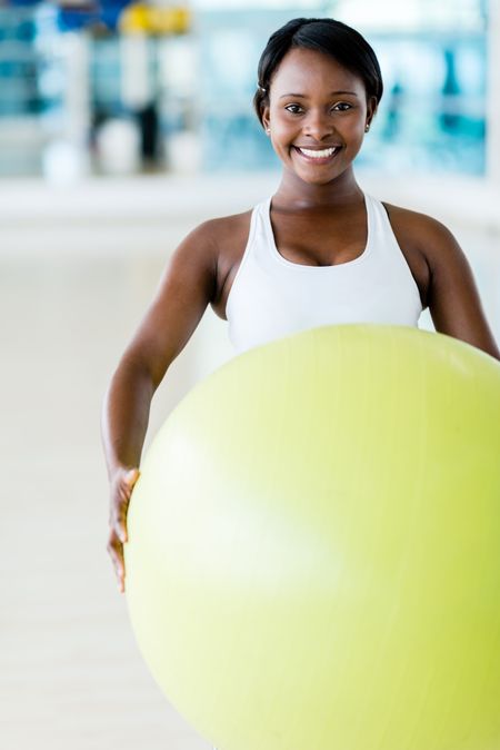 Beautiful woman doing Pilates at the gym with a Swiss ball
