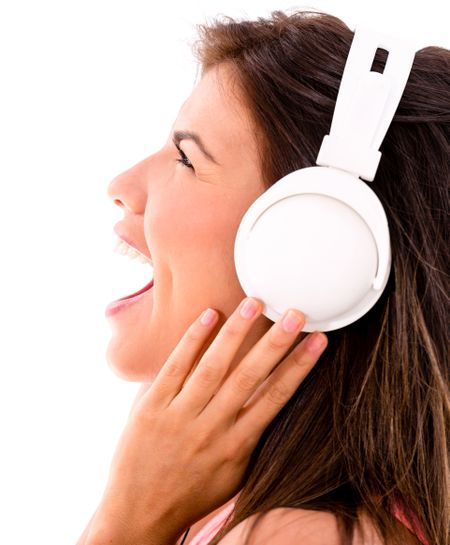 Happy woman loving music headphones and singing - isolated over white