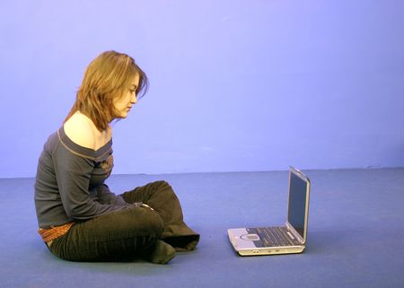 Girl using laptop on the floor