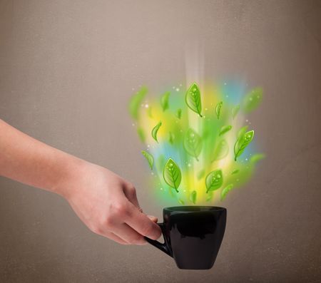 Tea cup with leaves and colorful abstract lights, close up