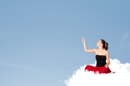 Beautiful young woman sitting on cloud with copy space