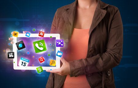 Young lady holding a tablet with modern colorful apps and icons