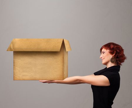 Beautiful young woman holding an empty cardboard box