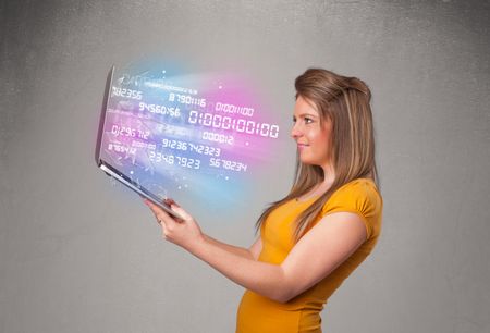 Attractive casual woman holding laptop with exploding data and numers