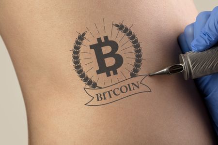 Hand tattooing cryptocurrency concept on naked clear skin
