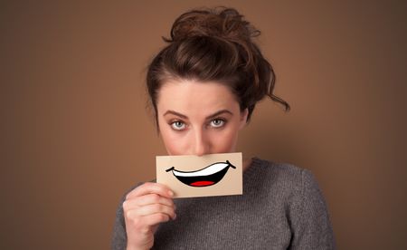 Person holding card in front of his mouth with ironic smile