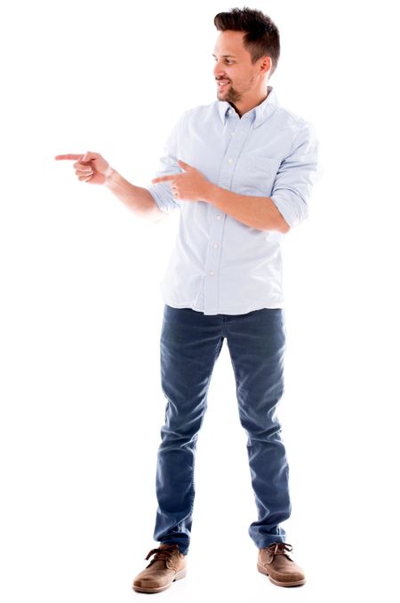 Casual man pointing to the side and smiling - isolated over white background
