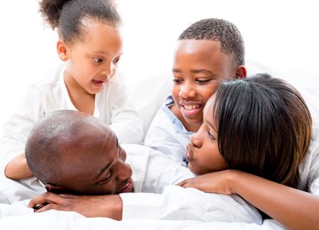 Beautiful family lying in bed and looking very happy 