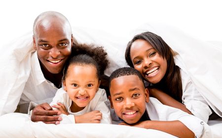 Beautiful happy family in bed - isolated over a white background 