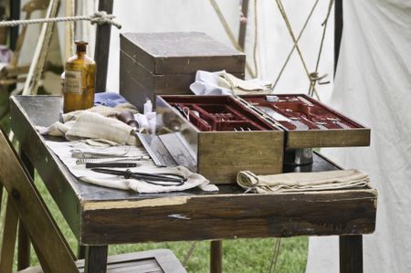 Instrument table in surgeons's tent, with bottle of chloroform and amputation saw, at reenactment of American Civil War (1861-1865), Lombard, Illinois (foreground focus)