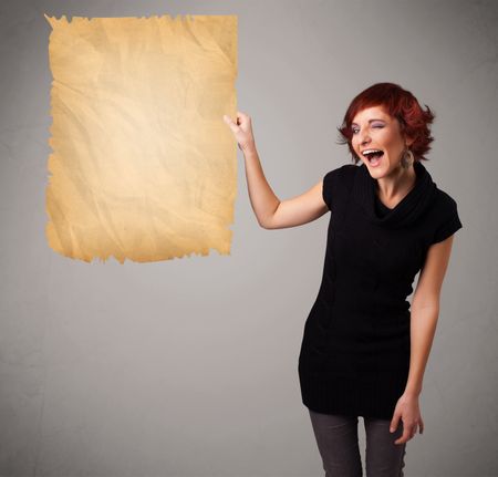 Beautiful young girl presenting old paper copy space