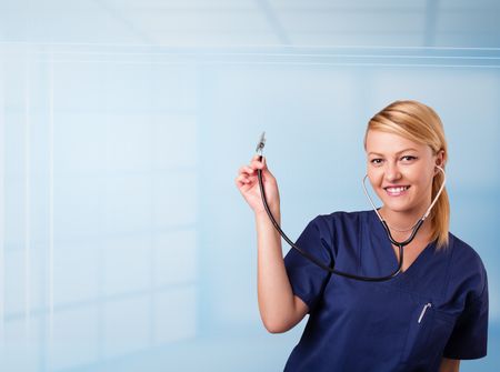 Pretty young nurse in hospital listening to empty copy space with sthetoscope