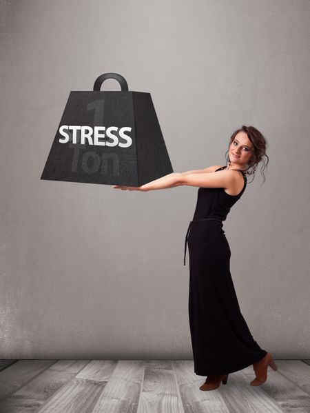 Attractive young woman holding one ton of stress weight
