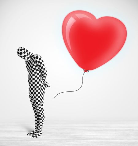 Cute guy in morpsuit body suit looking at a red balloon shaped heart