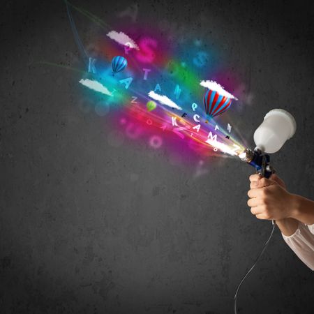 Worker with airbrush and colorful abstract clouds and balloons concept