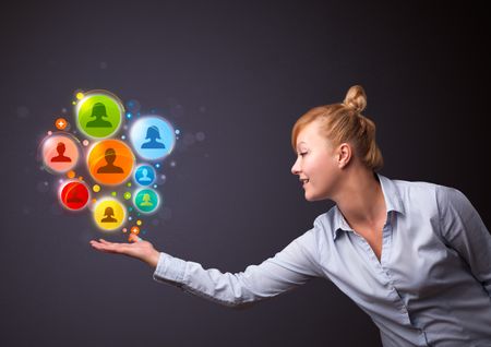 Young businesswoman holding colorful social network icons in her hand
