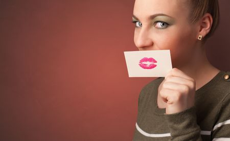 Person smiling with a card on the front of his mouth with a red lips on it