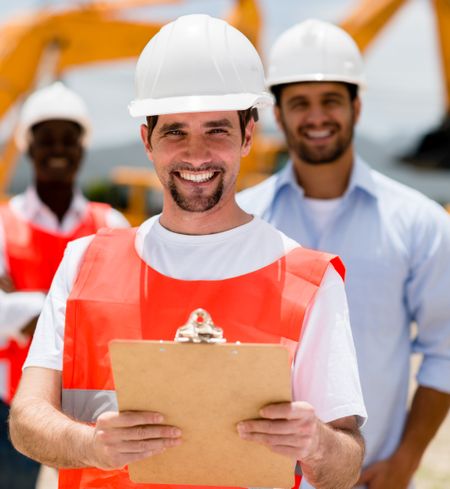 Happy construction worker holding a clipboard and smiling 