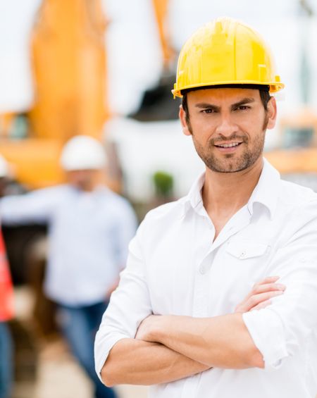 Male architect with arms crossed working at a construction site 