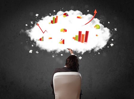 Young businessman sitting in an office chair with colorful charts in a cloud above his head