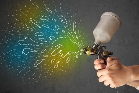 Worker with airbrush gun paints colorful lines and splashes concept
